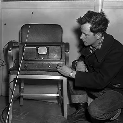 Vintage photo of man tuning a TV set