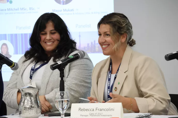 Two women speaking on a media panel with microphones