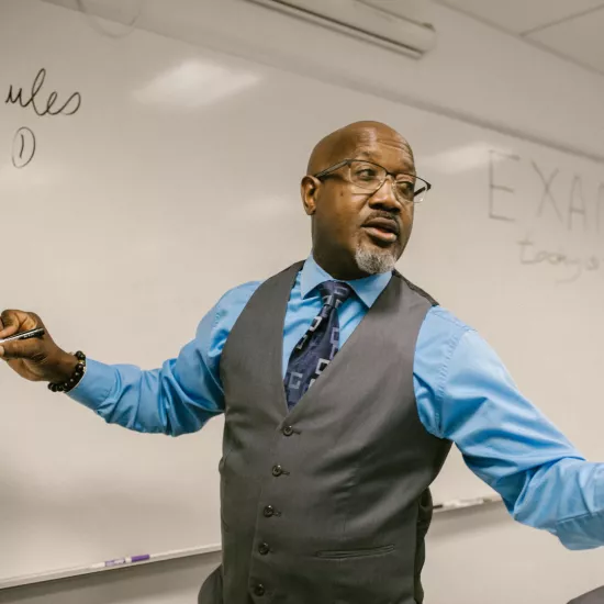 Professor speaking in front of whiteboard
