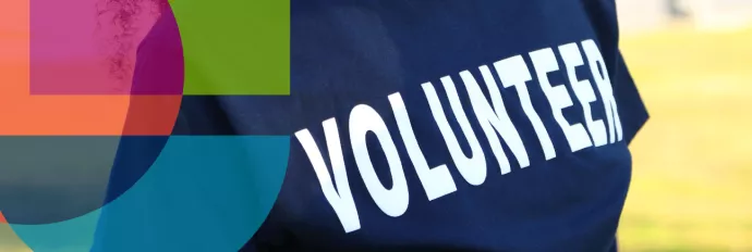 Closeup image of a student wearing a navy blue t-shirt that reads "volunteer " in white. Image features an RGASC logo on the left side.