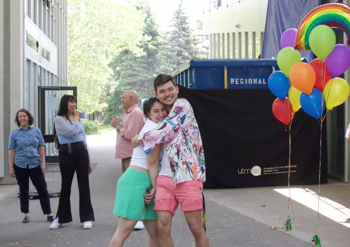 Friends embrace on UTM campus during a Pride Month event