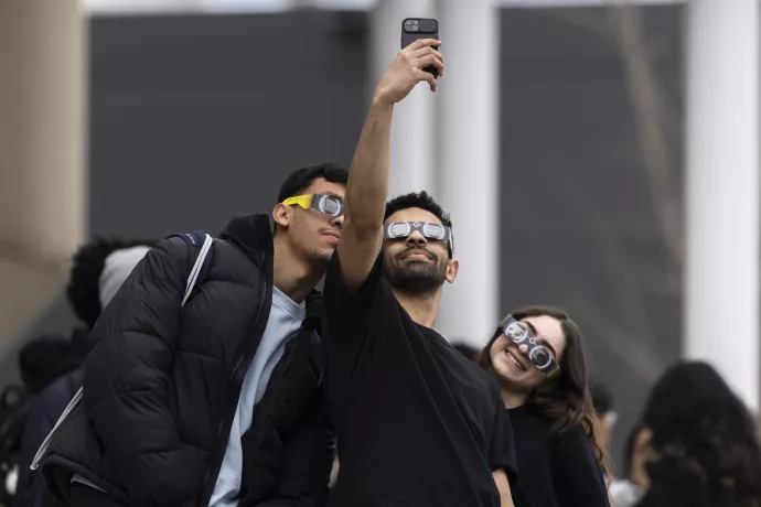 Attendees take a selfie wearing their solar eclipse safety glasses