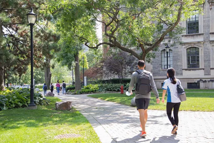 Two students walking along a path on the St. George campus