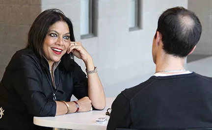 Mira Nair speaks to attendee at event