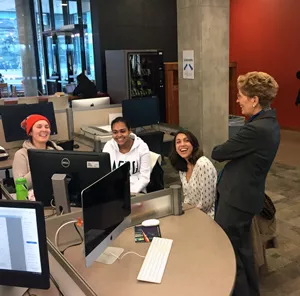 Wynne at library talking to three female students