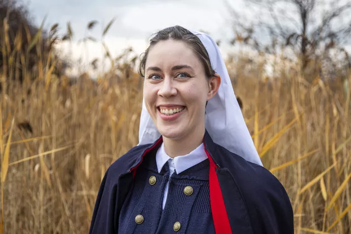 Madeleine Mant wearing authentic nursing uniform pieces that include a WWI uniform belt and WWII woolen cape.
