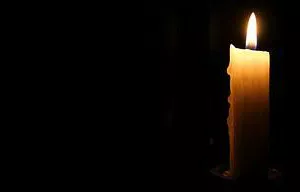 lighted candle against a dark background