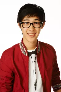 Andre Dae Kim wears glasses and a red cardigan as his Degrassi character Winston Chu.