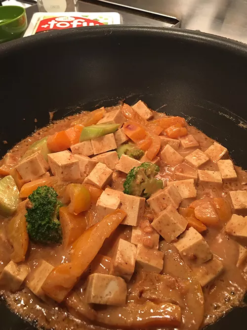 Pan of cubed tofu with brown sauce and broccoli