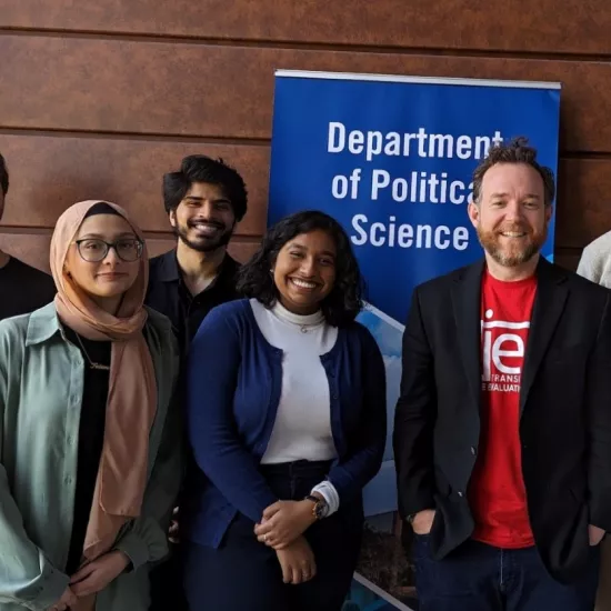Group photo of students and professor with a "Department of Political Studies" banner behind them