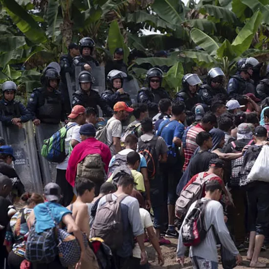 A new group of Central American migrants walk past Mexican Federal Police 