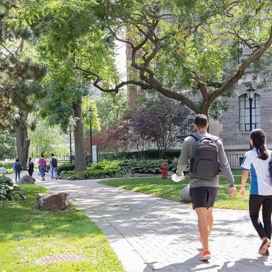 Two students walking along a path on the St. George campus