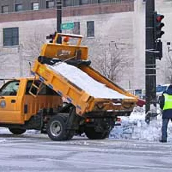 Workers manually spreading salt from a salt truck in Milwaukee, Wisconsin.