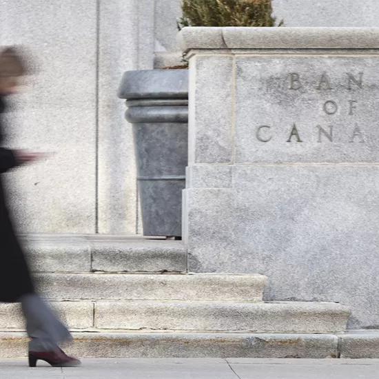 Woman walking by front of building with sign that reads Bank of Canada