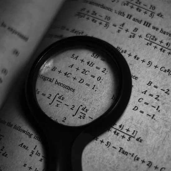 Image of math formulas in a textbook with a magnifying glass over a section