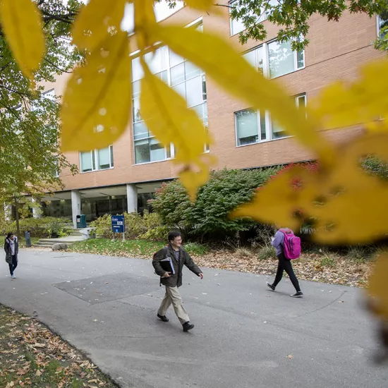 Students, faculty and staff walk beside the Erindale Hall residence at UTM