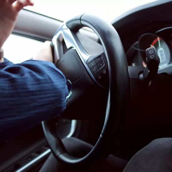 Photo of hands on steering wheel, turning the car
