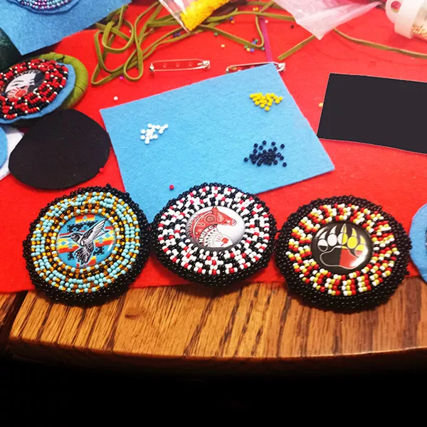 Three brightly coloured beaded medallions