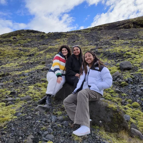 Three students on a rocky hillside