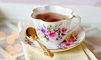 Tea cup with floral pattern on saucer with spoon