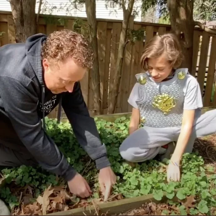 Image of Johnson digging in the garden with a young boy
