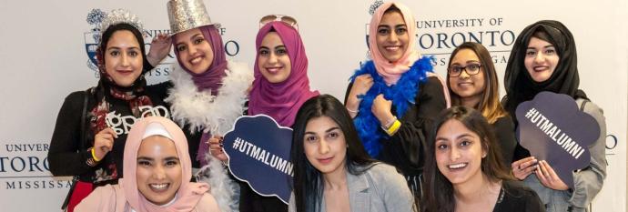 group of students smiling  at a grad reception photobooth