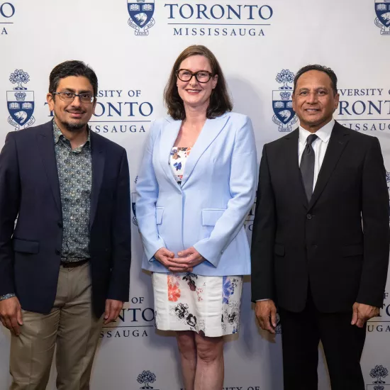 Photo of Vahed and Nirula with Alexandra Gillespie in front of a step-and-repeat with the UTM logo