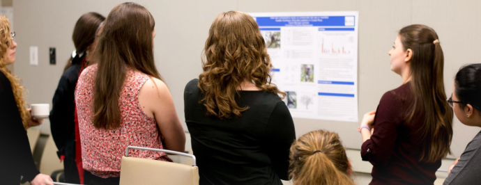 students view a research poster presentation