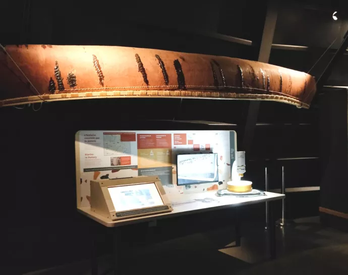 canoe over display with screens at museum