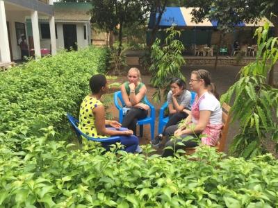 Students in conversation in a garden in Moshi.