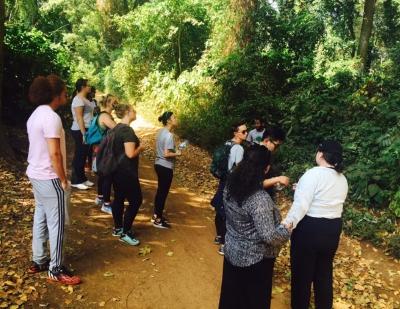 A group of students in discussion on a shady path under trees in Moshi.
