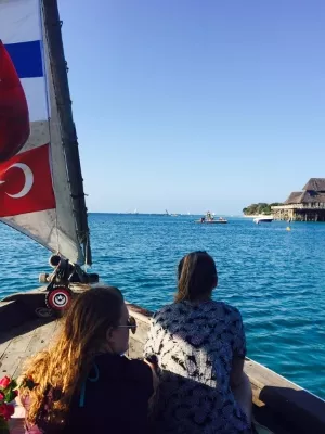 Two students sitting in a sailboat in waters off Zanzibar.