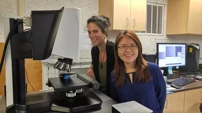 Liye Xie and Tiziana Gallo next to the Sensofar microscope