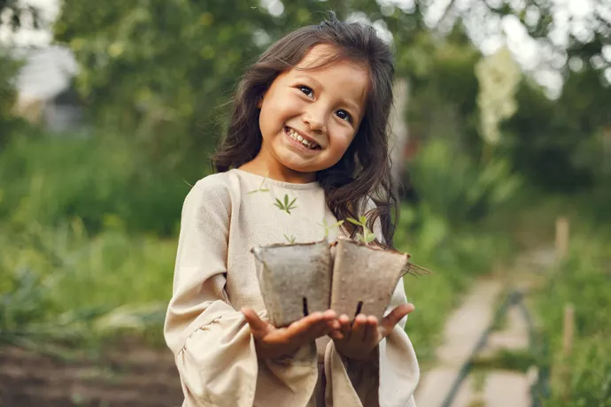 Child holding seedlings ready to be planted 