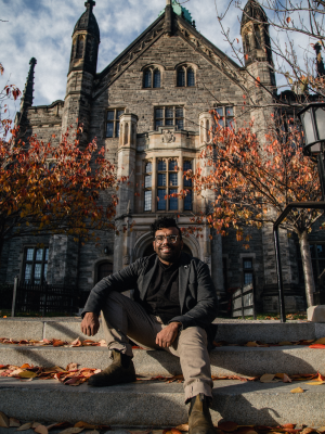 Headshot of Arun Jacob in front of University of Toronto college 