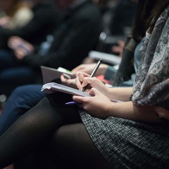 People seated and taking notes in a conference setting. Photo by the Climate Reality Project on Unsplash