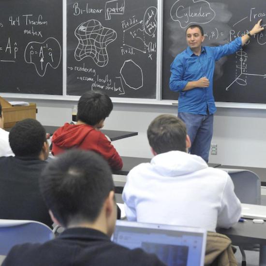 A lecturer at a blackboard, teaching a classroom of students at UTM