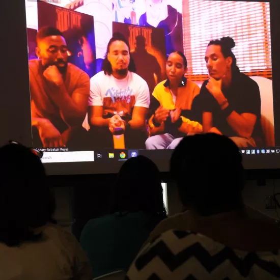 The Short Drop Team of Kern Salandy, Romario Reyes, Mary-Rebekah Reyes, and Israel Silva are on screen from Trinidad and Tobago at the watch party at UTM