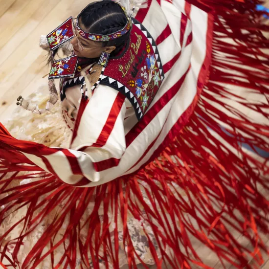 A dancer in red streamers at a Powwow