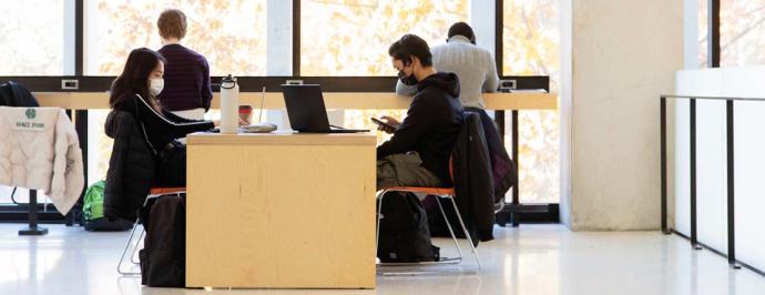 Masked students studying in an open study space