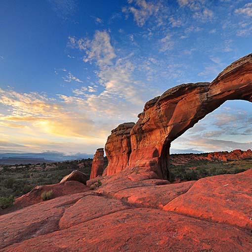 Rocky cliff at Arches National Park, with sunset in the background. Photo by NOAA on Unsplash
