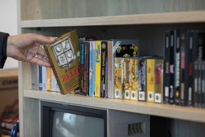 Person reaching for games on shelf