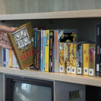 Person reaching for games on shelf