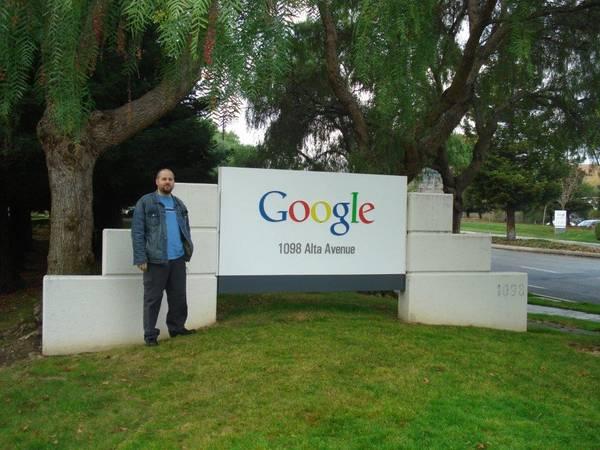 Photo of Anthony standing beside a large Google sign