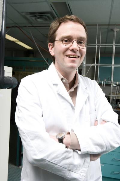 Photo of Ulrich Fekl standing, arms crossed, dressed in lab coat
