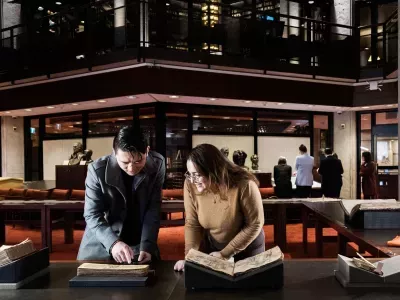 Researchers looking at ancient manuscripts in the Fisher Library