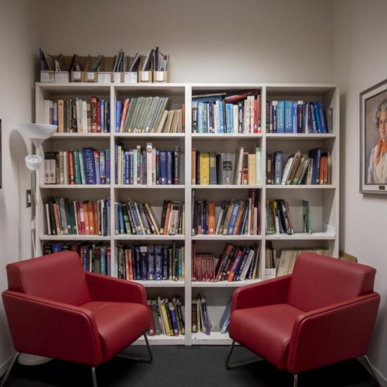 Two red chairs in front of bookshelf