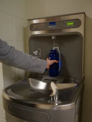 A bottle being filled at a water fountain