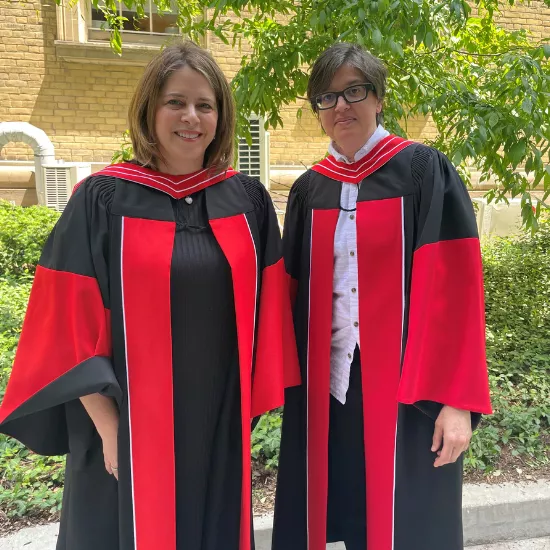 Two faculty in red and black robes