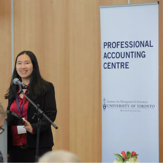 woman speaking in front of accounting banner